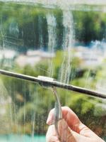 washing of home window glass by squeegee photo