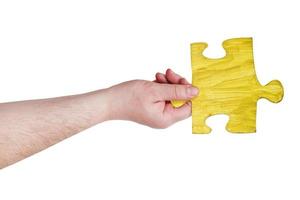 male hand with painted yellow puzzle piece photo