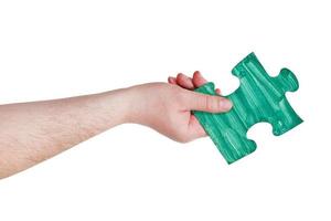 male hand with painted green puzzle piece photo