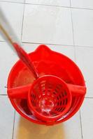 mop in red bucket with foamy water photo