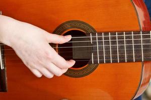 female hand plays on acoustic guitar photo