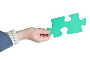 male hand holding big green paper puzzle piece photo