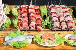 brochetas de shishkebabs y pescado crudo para la parrilla foto