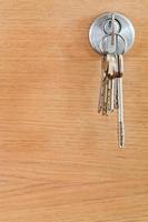 bunch of home keys in lock of wood door photo
