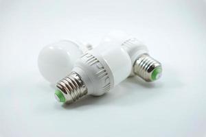 concept of three small white energy-saving light bulbs isolated on a white photo