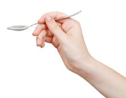 steel teaspoon in hand isolated on white photo