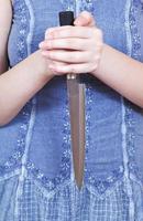 woman holding kitchen knife by two hands photo