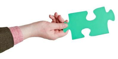 male hand holding big green paper puzzle piece photo