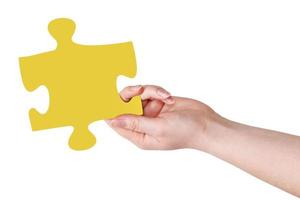 female hand with yellow puzzle piece photo