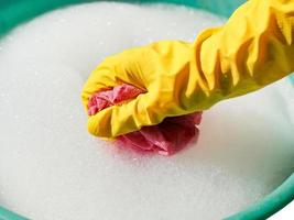 hand in yellow rubber glove rinsing wet cloth photo