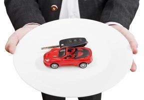 man holds white plate with red car and key photo