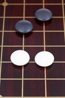 go game playing on dark wooden board photo