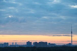 blue clouds and yellow sunrise sky over city photo