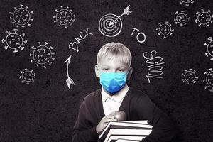 niño con máscara de protección contra el virus de la corona en la escuela. foto