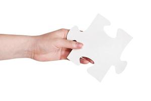 female hand holding big white paper puzzle piece photo