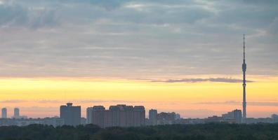 panorama of city under grey clouds at sunrise photo