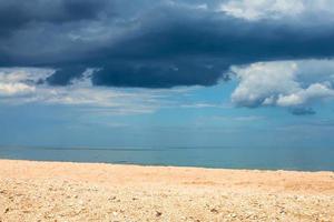 landscape with sand beach and rain clouds over sea photo