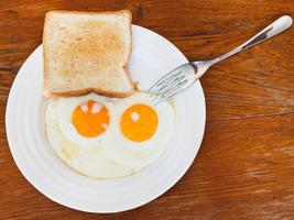 desayuno con dos huevos fritos en plato blanco foto