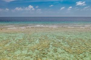 Coral reefs off the coast in Maldives islands, clear water as shallow ocean lagoon and amazing landscapes, seascape. Tropical island shore, exotic travel destination. Earth, ecology concept, sea view photo