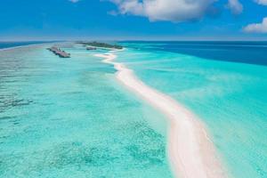 Panoramic landscape seascape aerial view over a Maldives atoll islands. White sandy beach seen from above. Perfect aerial landscape, luxury tropical resort or hotel with water villas beautiful beach photo