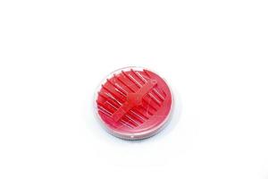 round red sewing needle holder isolated on a white photo