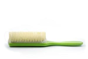 A used green hair comb has hair residue attached photo