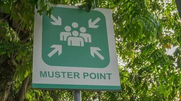 Muster Point signboard with green tree leaves background, photo