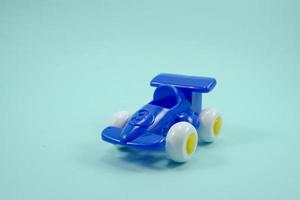 Blue paint plastic toy racing car with number three isolated on turquoise photo