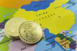 Stack of gold bitcoin coins with China on a world map background. photo