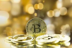 Stack of gold bitcoin coins with golden bokeh background. photo