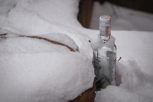 vilnius, lituania diciembre, 2021 una botella vacía de vodka lituano en nieve esponjosa foto