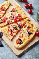 Puff pastry tart with cherry tomatoes, mozzarella and purple basil photo