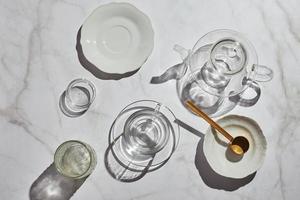 High angle view of glassware for tea shade on white table on sunny day photo