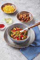 Quinoa with green beans, tomatoes, fried champignons, corn, red bell peppers, peas and soybeans. Healthy Vegetable Mix photo