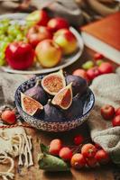 Dish with figs, apples and grapes with warm cozy knitwear, autumn leaves and apples. photo