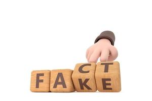 Hand turns dice and changes the word fake to fact. photo