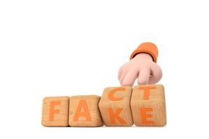 Hand turns dice and changes the word fake to fact. photo