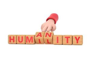 Hand turns dice and changes the word humanity to humility. photo