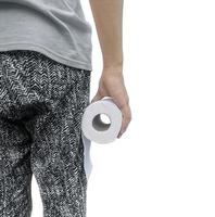 male hand holding a roll of toilet paper on a white background photo