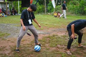 Blitar, Indonesia - September 11th 2022. Two young men who took part in a dribbling competition with eggplant to commemorate Indonesian Independence Day in Blitar in the afternoon photo