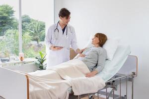 médico varón consultando a un paciente mayor. médico profesional con bata blanca hablando con una mujer madura. foto