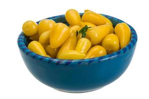 Yellow marinated pepper in a bowl on white background photo