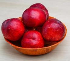 Nectarines in a bowl on white background photo