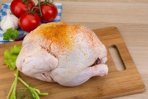 Raw chicken on wooden board and wooden background photo