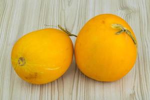 Small yellow melon on wooden background photo