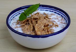 Cornfalkes desayuno en un bol sobre fondo de madera foto