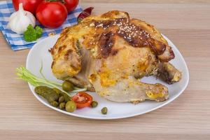 Grilled chicken on the plate and wooden background photo