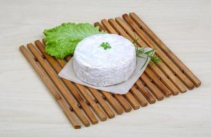 Camembert cheese on wooden board and wooden background photo