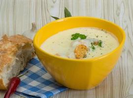 Cheese soup with croutons in a bowl on wooden background photo