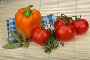 Tomato and pepper on wooden background photo